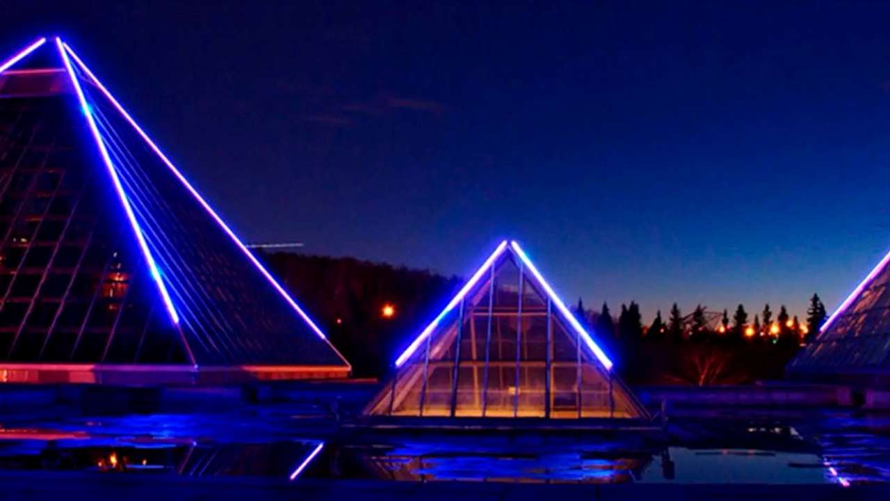 Pirâmides iluminadas em neon à noite — fachada de entrada da Clínica Pyramide na Mooca