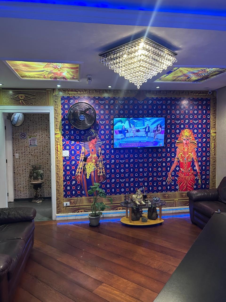 Recepção da Clínica Pyramide com decoração egípcia, lustre de cristal e sofás